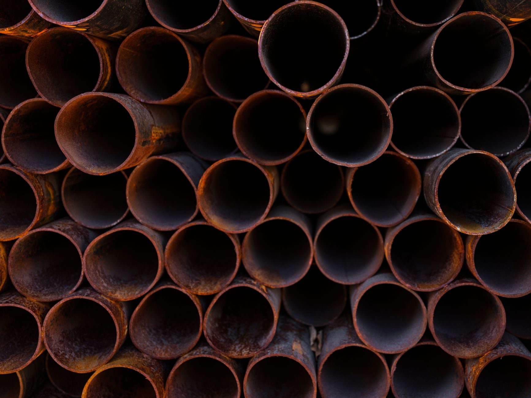 A stack of rusted steel pipe ends seen face-on