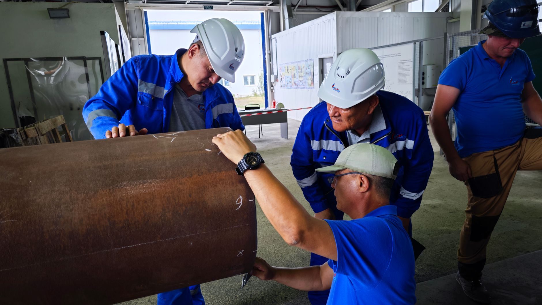A field crew examining the end of a large steel pipe section during an inspection
